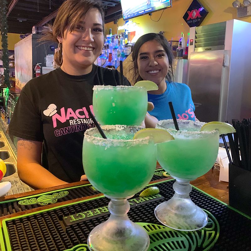 Nacho's bartenders with green margaritas at the bar
