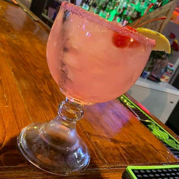 A strawberry margarita with a sugared rim