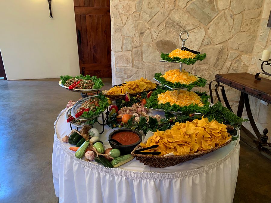 A tiered chips, salsa and toppings display at a catered event