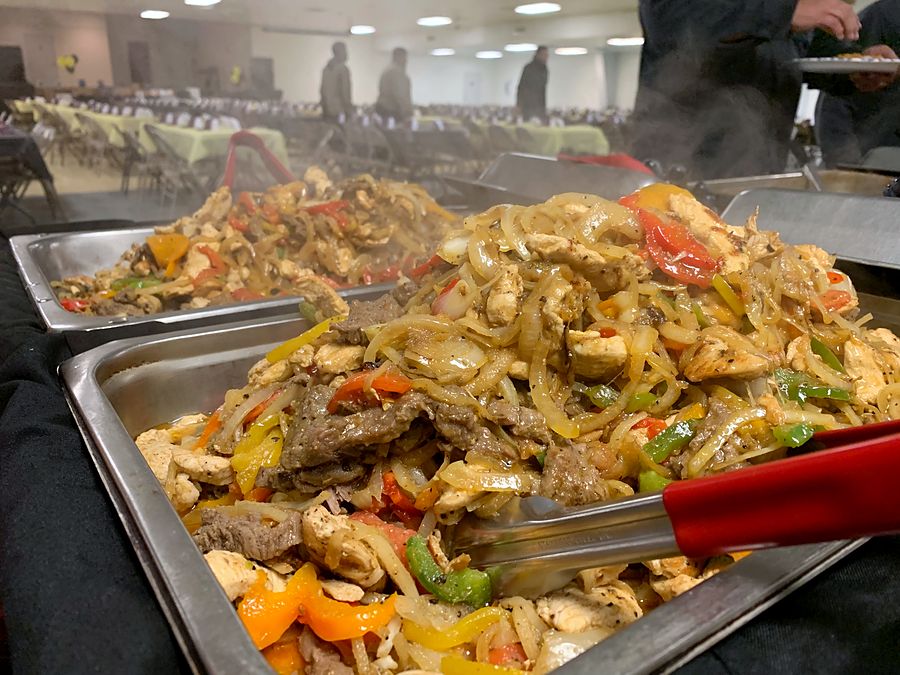 Pans of chicken and steak fajitas at a Nacho's catered event